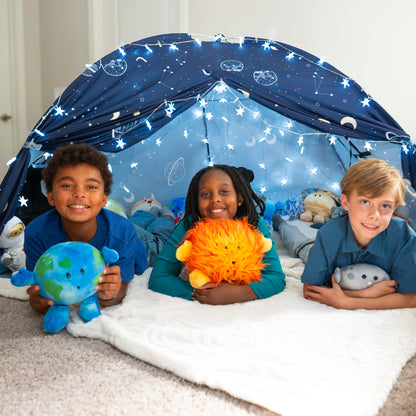 Three kids resting on their elbows holding space plushies are playing in a space-themed tent with the Best Seller Bundle. Earth Buddy, Sun Buddy, Moon Buddy.