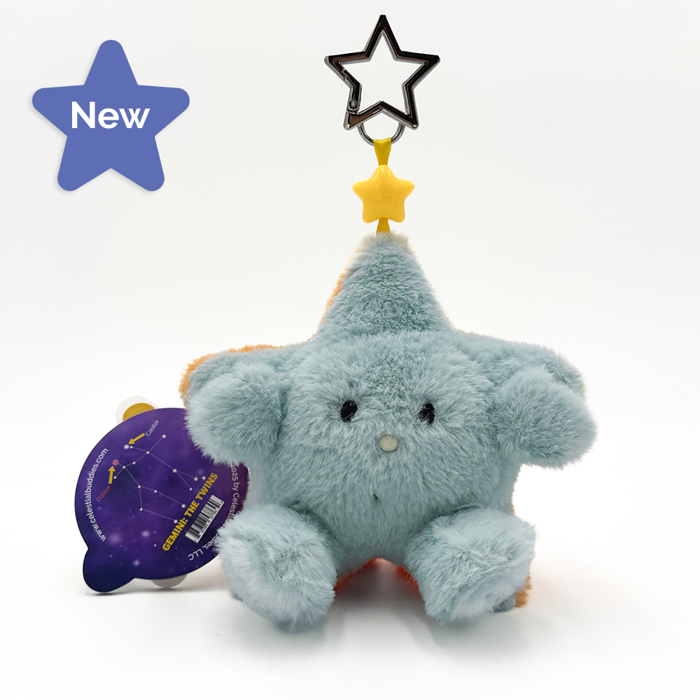 A plush star-shaped keychain in light blue with orange accents, featuring a star-shaped hanging attachment at the top and a purple circular papere tag attached on the left, photographed on a white background.