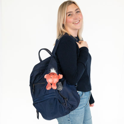 A woman wearing a navy blue backpack with Nano Mars plush Keychain attached to the side, posing against a plain white background.